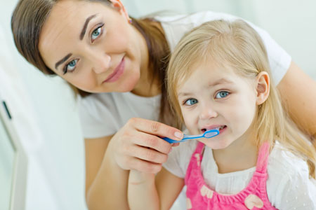 Mom and Daughter brushing their teeth - Pediatric Dentist & Orthodontics in Garland, TX